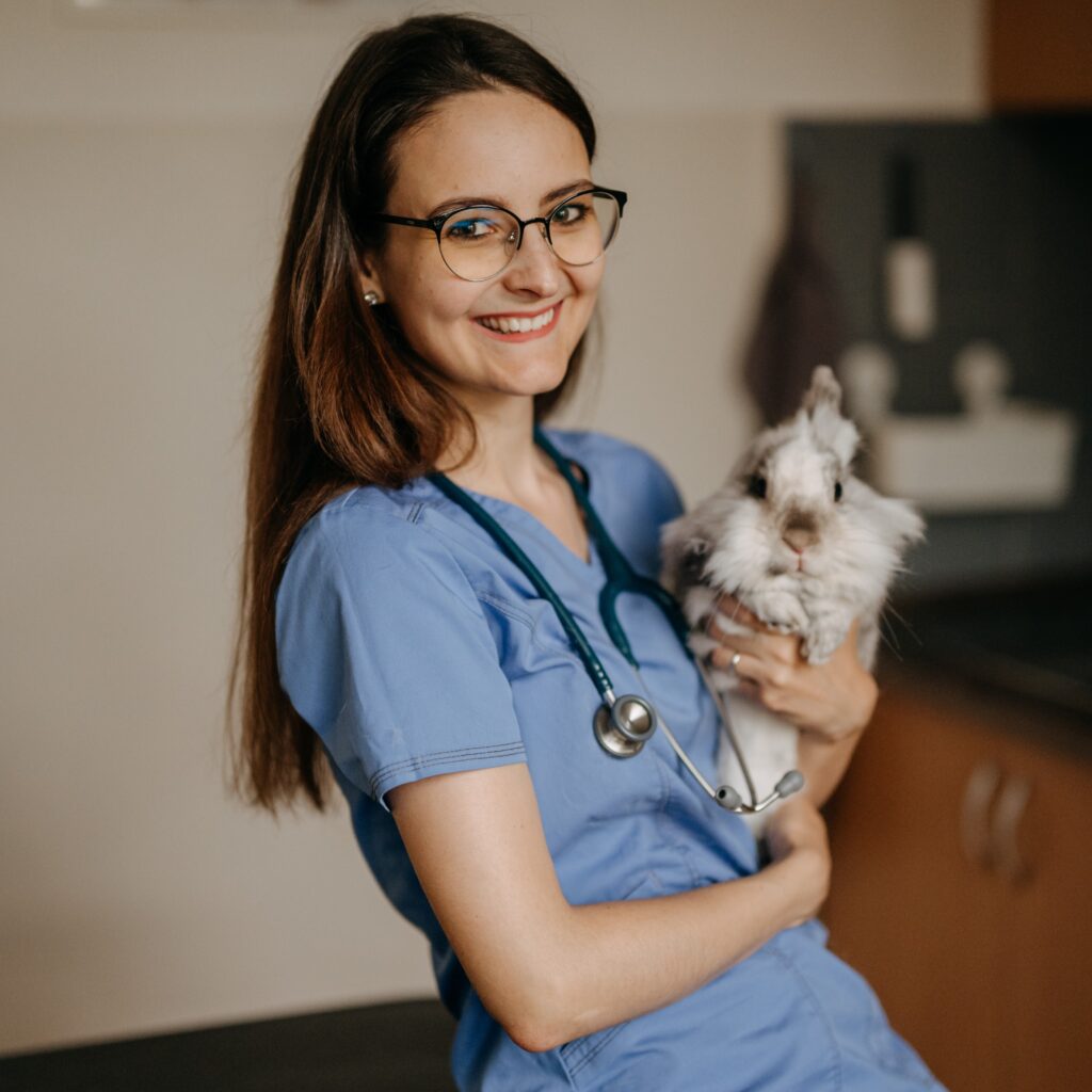 Veterinářka MVDr. Kristýna Pouzar Pokrupová drží bílého králíka plemene lvíček